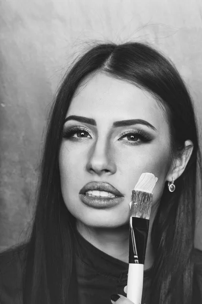 Sexig brunett kvinna ansikte med artist eller makeup borste — Stockfoto