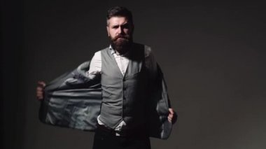 Yakışıklı genç sakallı işadamı Klasik takım elbise ceketi ayarlıyor. Sakallı adam farklı duygularla.
