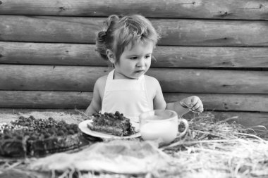 Küçük çocuk meyveli kek yiyor