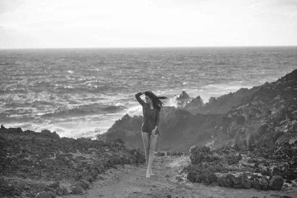 Bella ragazza si trova sulla spiaggia rocciosa — Foto Stock