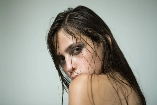 Žena s mokrými nebo zaolejovanými vlasy na šedém pozadí — Stock fotografie