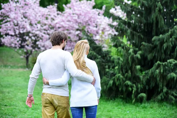 Kadın ve adam sarılmak çiçek açması bahçede arkadan görünüm — Stok fotoğraf