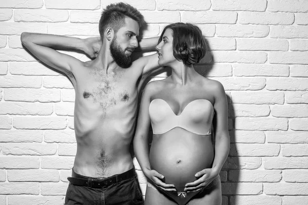 Barbudo delgado hombre y bonita mujer embarazada con vientre redondo —  Fotos de Stock