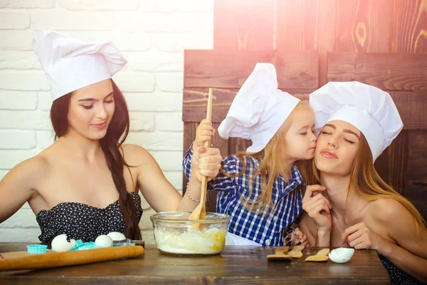 Irmão e irmãs em chapéus de chef preparando massa — Fotografia de Stock