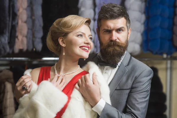 Mann mit Bart und Frau kaufen pelzigen Mantel. — Stockfoto