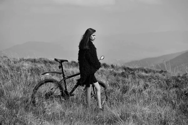 Chica con bicicleta en la montaña — Foto de Stock