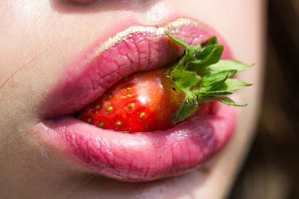 Morango na boca com lábios rosados, maquiagem — Fotografia de Stock