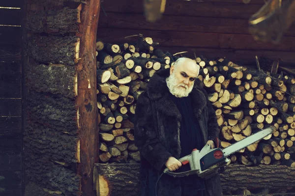 Old bearded man with chainsaw — Stock Photo, Image