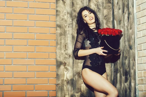 Menina muito feliz com rosas vermelhas na caixa de presente — Fotografia de Stock