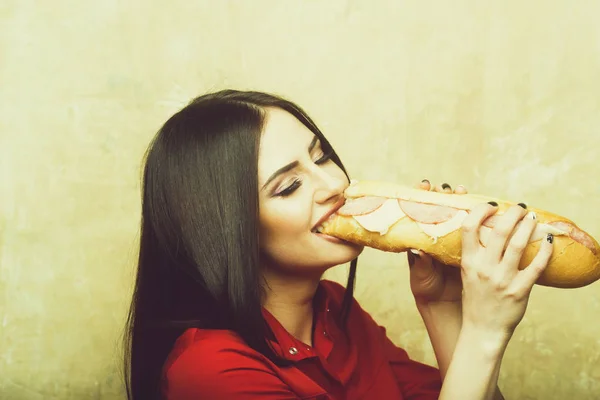 Sexy kobieta uśmiechający się ładny brunetka zjada sandwich duże lub burger — Zdjęcie stockowe