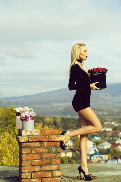 Hübsches Mädchen mit Blumen in Schachteln — Stockfoto