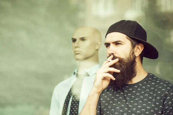 Bearded man smoking near showcase — Stock Photo, Image