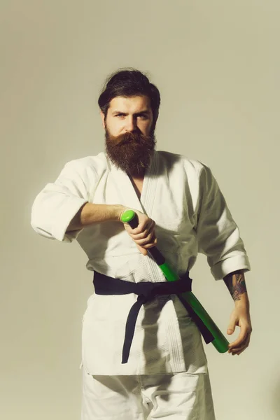 Bearded serious karate man in kimono with green baseball bat — Stock Photo, Image