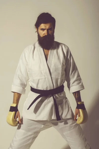 Bearded serious karate man in kimono and boxing gloves — Stock Photo, Image