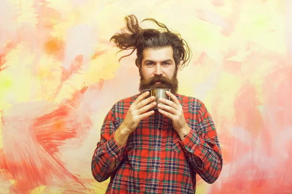 Бородатый мужчина держит металлическую кружку на абстрактном фоне — стоковое фото