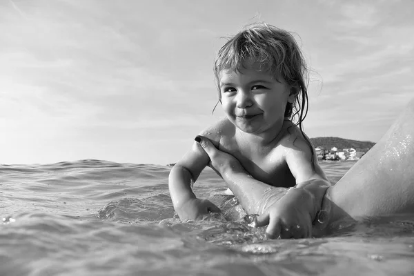 Милый малыш плавает в воде. . — стоковое фото