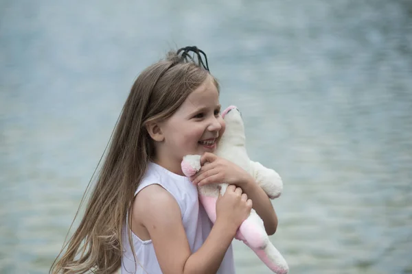 Girl with long hair smile with soft toy — Stock Photo, Image