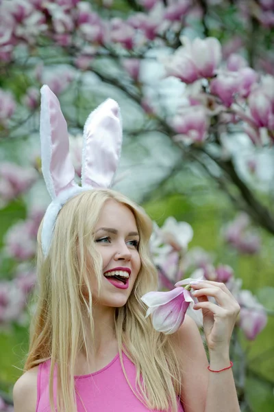 Vrouw of leuk meisje met bunny oren op bloeiende magnolia — Stockfoto
