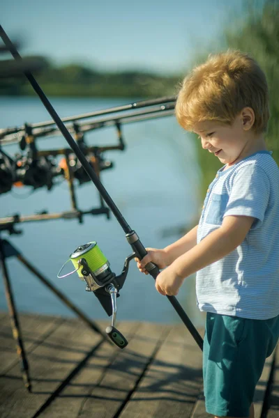 Sonrisa infantil con caña de pescar en muelle de madera — Foto de Stock