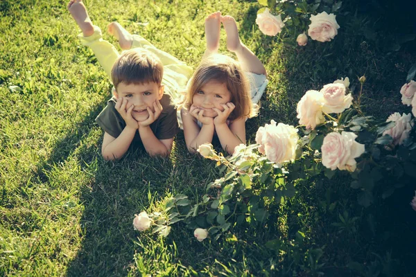 Yeşil Çim Yaz Bahçesinde Yatan Çocuklar Erkek Kız Bahçesinde Çiçek — Stok fotoğraf