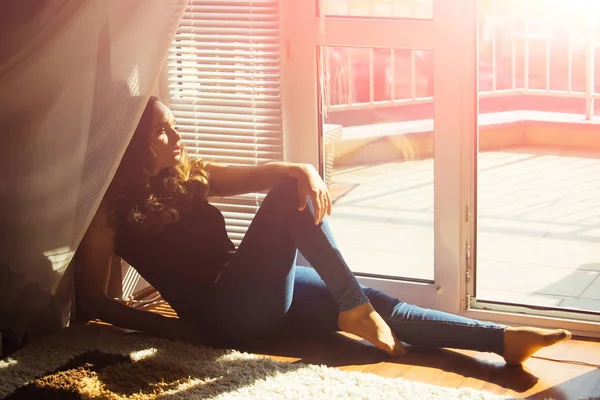 女孩在牛仔裤放松在地板在门窗口室内 — 图库照片