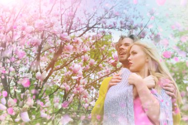 Genç çift çiçek açan çayırda. Çift çiçek açan parkta eğleniyor