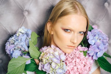 Ortanca çiçek gri duvar ile makyaj modeli