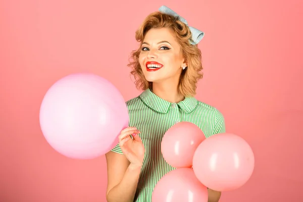 Sexy blond girl with retro makeup hold balloons.
