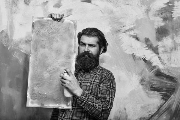 Turuncu yağlı boya doku tuval üzerinde tutarak ciddi sakallı adam — Stok fotoğraf