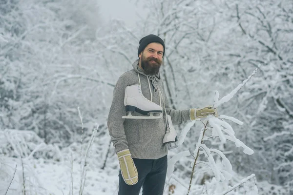 Homem barbudo com patins na floresta nevada . — Fotografia de Stock