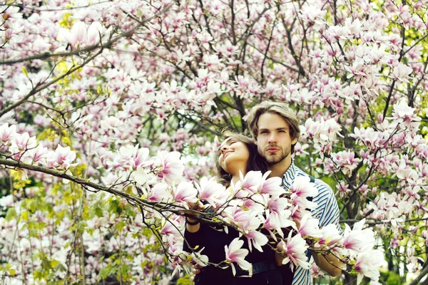 Bonito homem e menina bonita desfrutando flor de magnólia — Fotografia de Stock