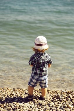 Çakıl plajı üzerinde erkek bebek