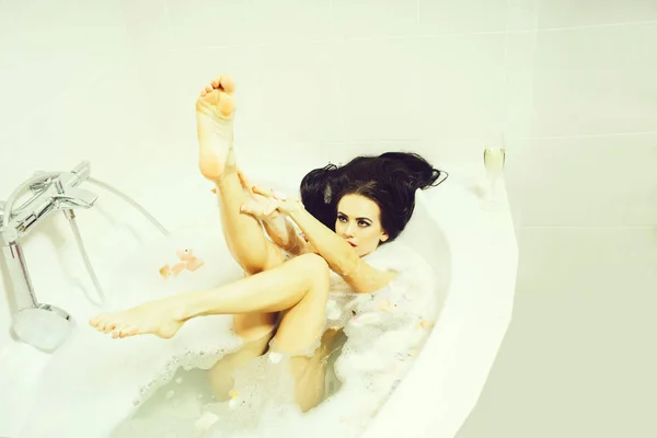 Сексуальная женщина в ванной с лепестками — стоковое фото