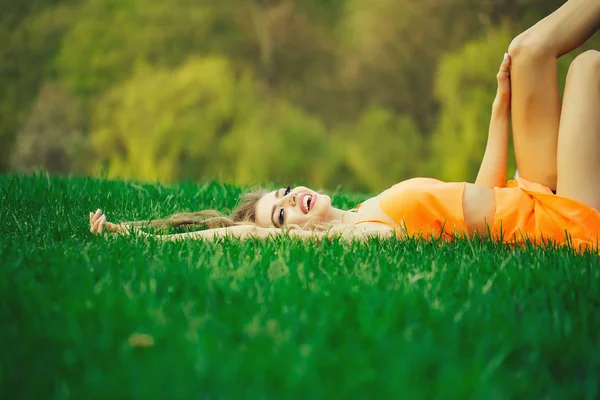 Γυναίκα ξαπλωμένη στο πράσινο γρασίδι — Φωτογραφία Αρχείου