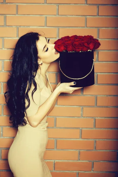 Vacker flicka att lukta rosor i låda — Stockfoto