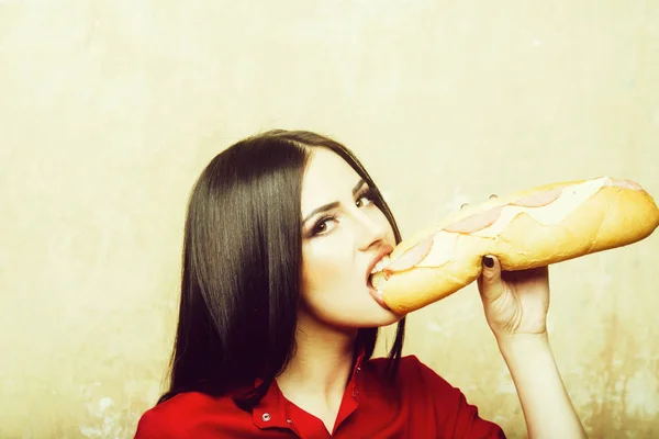 Sexig brunett kvinna äter stora smörgås eller burger — Stockfoto