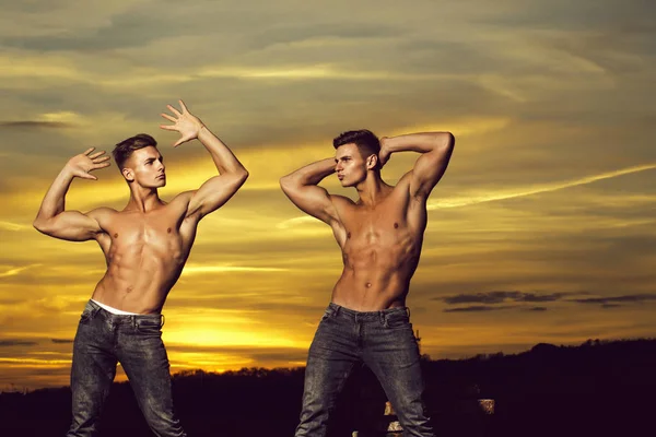 Hombres musculosos en la puesta de sol con cajas — Foto de Stock