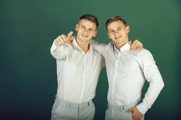 Két testvér, mosolyogva, és mutat ujj — Stock Fotó