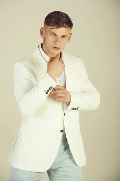 Модель позирует в белой куртке, полосатой рубашке и синих брюках — стоковое фото
