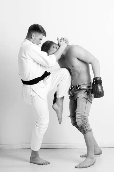 Άνδρες αγωνίζονται στο καράτε κιμονό και γάντια του μποξ — Φωτογραφία Αρχείου