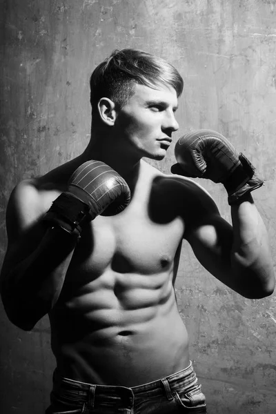 Boxeador homem com luvas de boxe vermelho em braços musculares — Fotografia de Stock