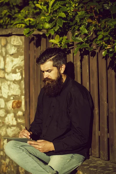 Бородатий чоловік на відкритому повітрі з олівцем і нотою — стокове фото