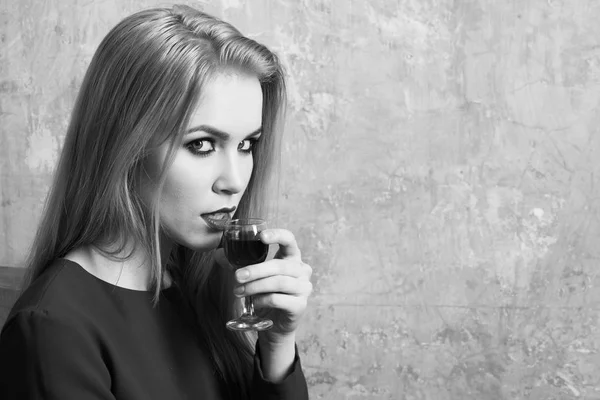 Girl drinking red liqueur in glass