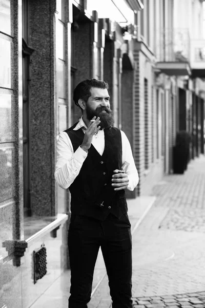 Чоловік посміхається і курить сигарету з пляшкою — стокове фото