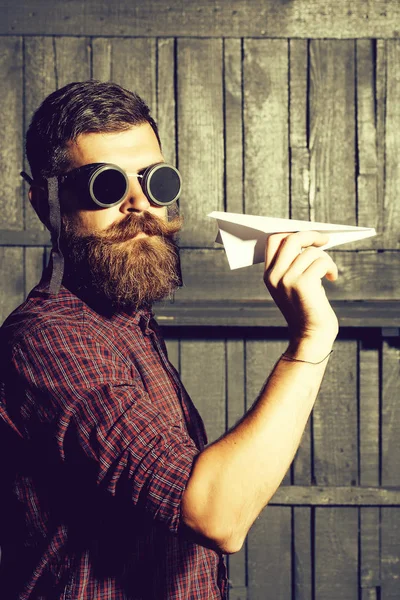 Bearded man throws paper plane