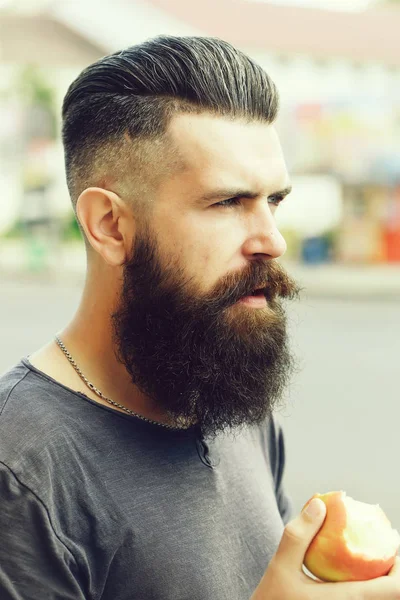 Bearded man eating apple