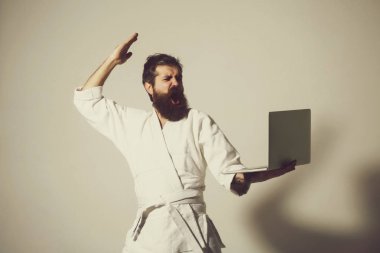 kimono dizüstü bilgisayar ile erkekte karate bağırarak sakallı