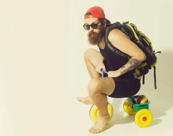 Bearded serious man with bag, apple on bicycle toy — Stock Photo, Image