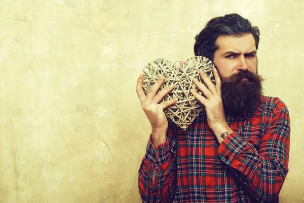 Homme barbu à longue barbe tient coeur en osier — Photo