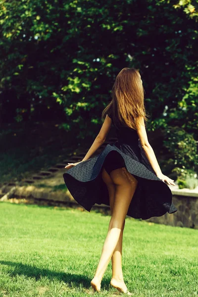Rapariga atraente em vestido da marinha no gramado — Fotografia de Stock